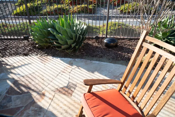 Terrasse mit Holzstuhl, Sonance Landscape-Satellit im Beet daneben